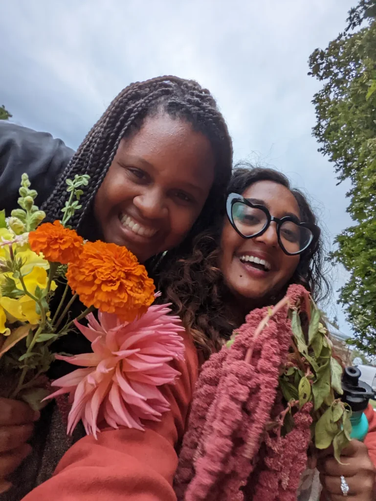 Two women happy outdoors holding flowers