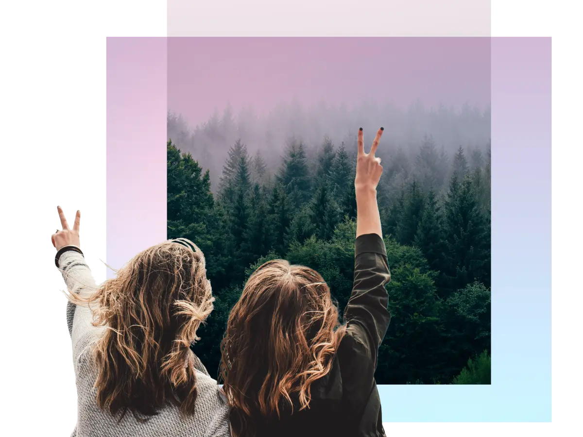 two women giving peace signs at a forest